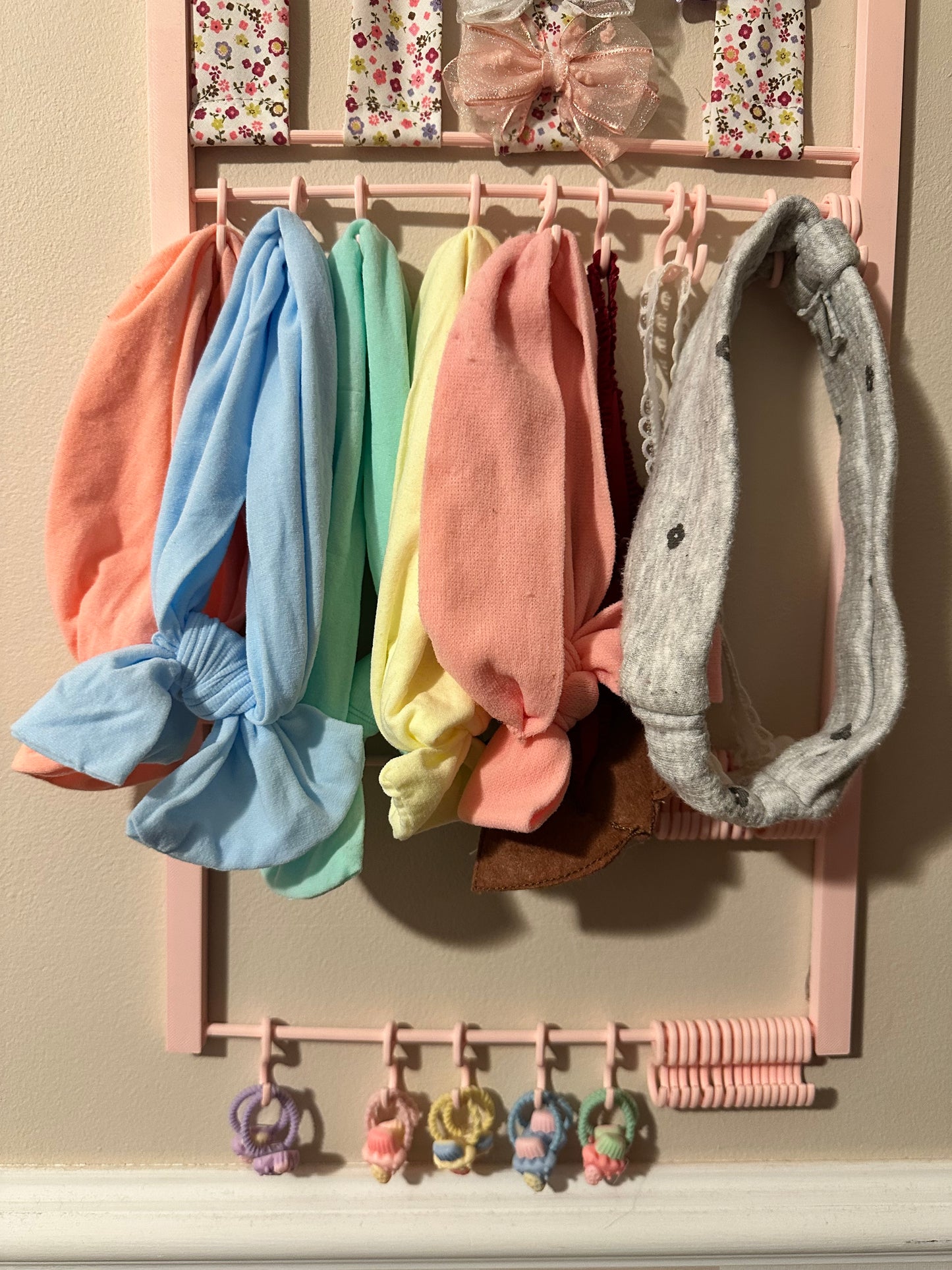 Organizador de diademas y gomas de pelo decorativo para habitación de niña con accesorios ordenados por colores y tipos