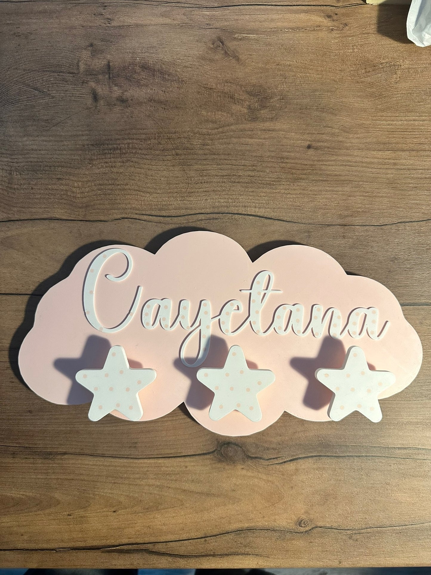 Perchero infantil de pared personalizado con forma de nube en color rosa con nombre en relieve y colgadores de estrella