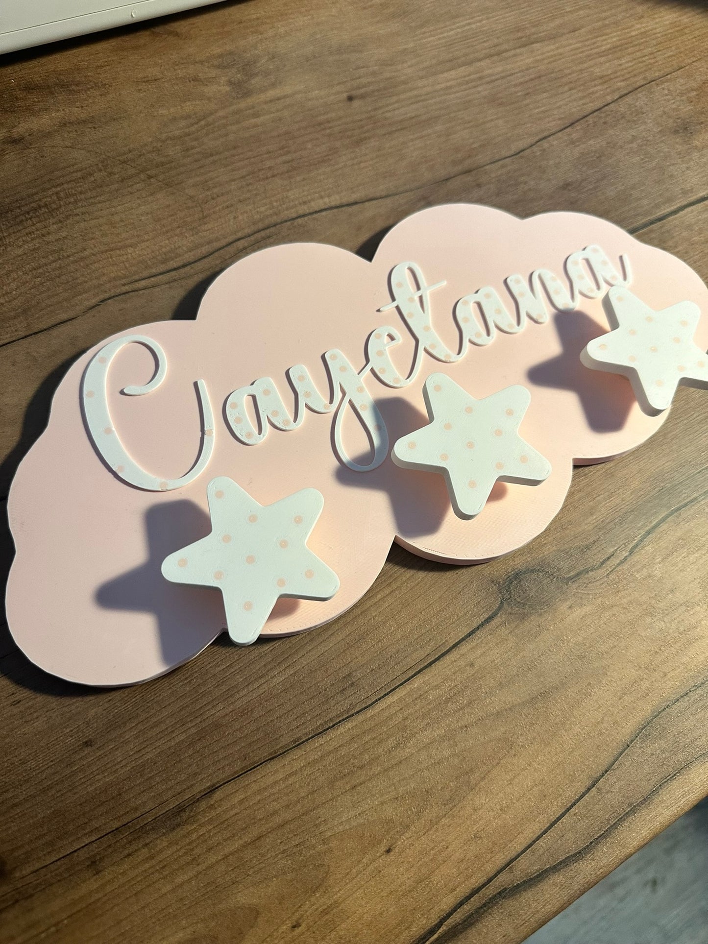 Perchero infantil de pared personalizado con forma de nube en color rosa con nombre en relieve y colgadores de estrella