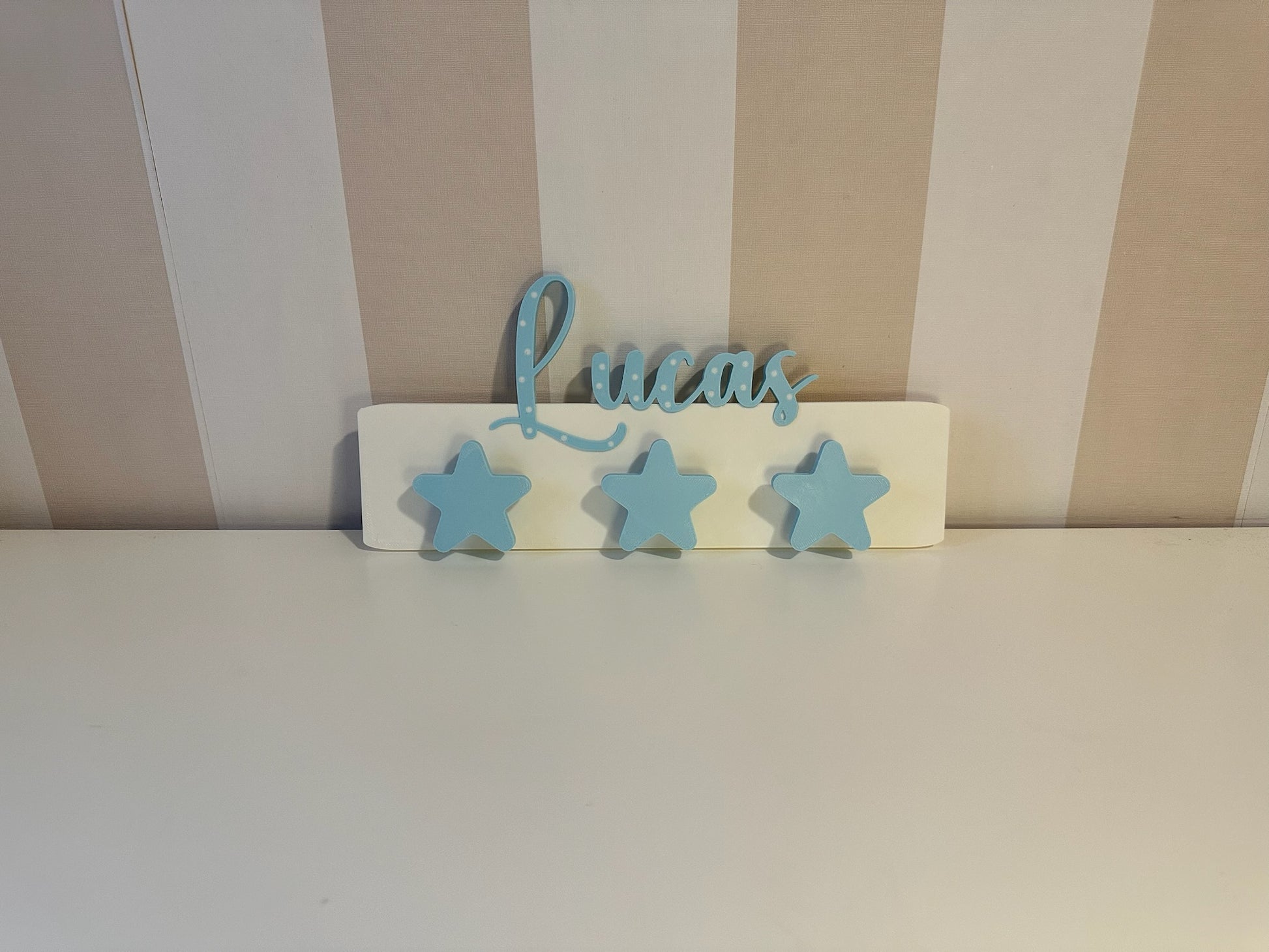 Percha pared infantil rectangular color azul con nombre personalizado en relieve y colgadores de estrellas para habitación niño